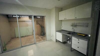 Small kitchen with sink and sliding doors leading to an outdoor area