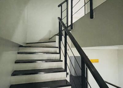 Staircase with black steps and metal railings