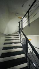 Staircase with black steps and metal railings