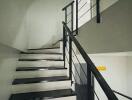 Staircase with black steps and metal railings