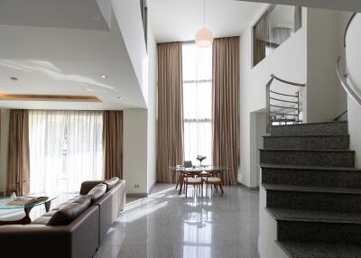 Spacious modern living area with large windows and a staircase