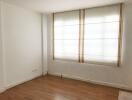 A minimalistic bedroom with a window covered by blinds