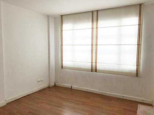 A minimalistic bedroom with a window covered by blinds