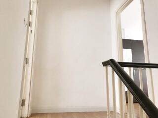 Simple white hallway area with wooden flooring