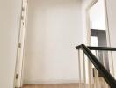 Simple white hallway area with wooden flooring