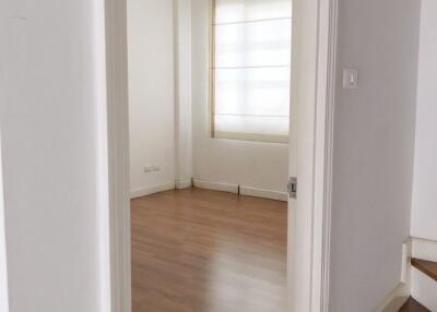 Empty bedroom with wooden floor and large window