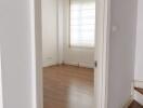 Empty bedroom with wooden floor and large window