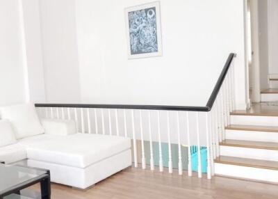 Modern living room with white sofa and staircase