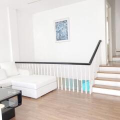 Modern living room with white sofa and staircase