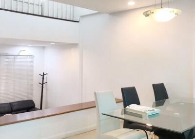 Modern dining area with glass table and black and white chairs