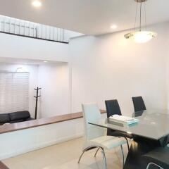 Modern dining area with glass table and black and white chairs