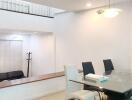 Modern dining area with glass table and black and white chairs