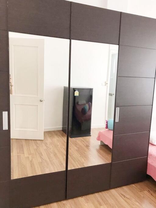 Bedroom with mirror wardrobe and wooden floor