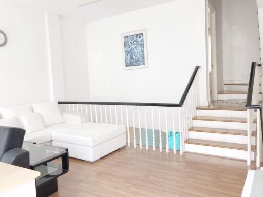 Modern living area with white sofa and hardwood flooring