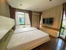 Modern bedroom with two beds, wall-mounted TV, air conditioning, and large windows