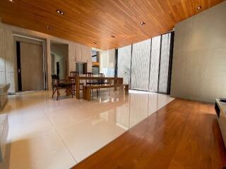 spacious modern living room with wooden ceiling and floor