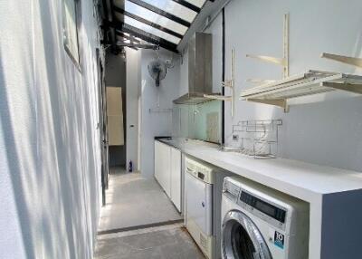 Narrow laundry area with glass roof