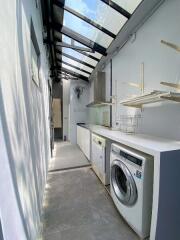 Narrow laundry area with glass roof