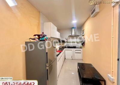 Modern kitchen with white cabinets, stainless steel refrigerator, and a black table