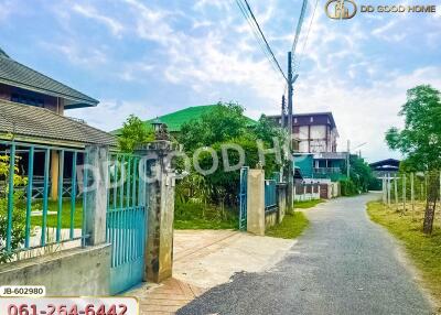 Entrance to residential property with gate and paved road