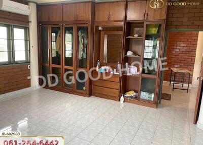 Spacious bedroom with built-in wooden wardrobe and large windows