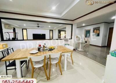 A modern dining room with wooden table and chairs, adjacent to a living room