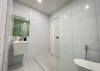 Modern bathroom with white tiles and glass shower