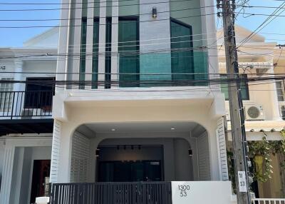 Front view of a modern two-story house with a gated entrance