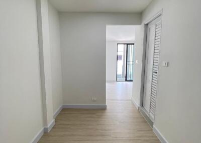 Bright hallway with wood flooring and white walls