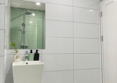 Modern bathroom with white tiles and glass shower enclosure