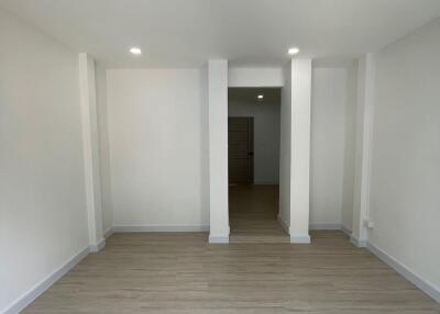 Empty living room with wooden floor and white walls