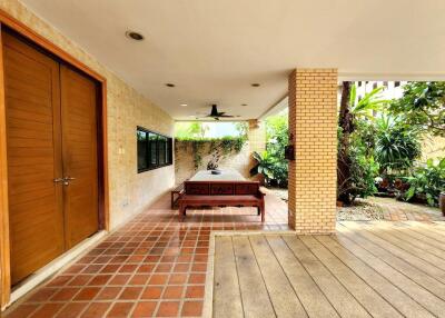 Outdoor patio area with wooden doors and greenery