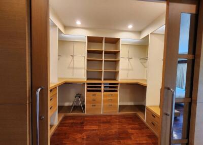 Spacious walk-in closet with wooden shelves and drawers