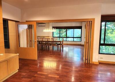 Spacious living room leading into a dining area with large windows