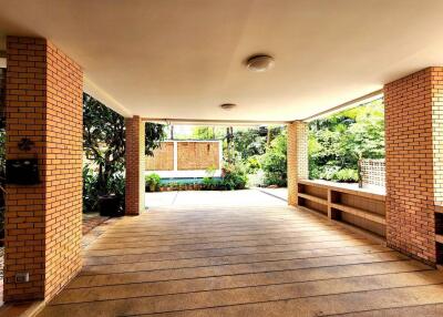 Spacious covered outdoor area with brick pillars and garden view