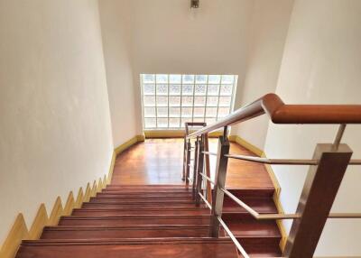 Well-lit wooden staircase with metal railing