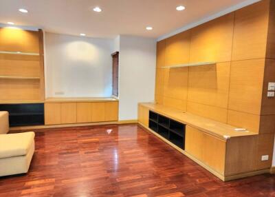 Spacious and modern living room with hardwood floors and built-in shelving