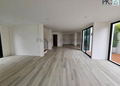 Modern living area with wooden flooring and large windows