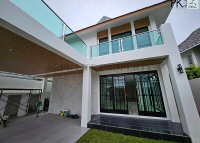 Modern two-story house with glass balcony and covered outdoor area