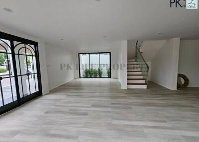 Spacious modern living room with large windows and staircase