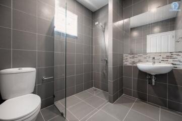 Modern bathroom with grey tiles and walk-in shower