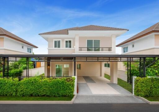 Exterior view of a modern two-story house with a driveway and surrounding greenery