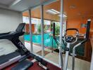 Fitness room with exercise equipment and view of indoor swimming pool