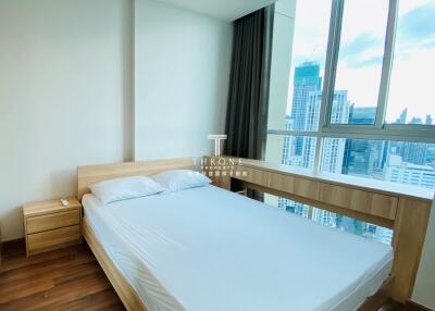 Bedroom with large windows and city view