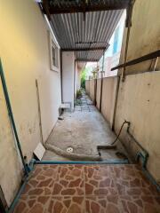 Outdoor alleyway with tiled floor and corrugated metal roof