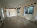 Spacious living room with tiled floor and large windows