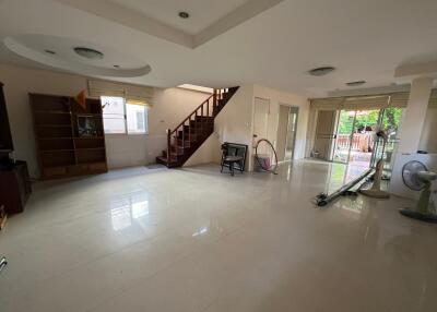 Spacious living room with tile flooring and a staircase