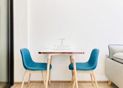 Small dining area with table and two blue chairs
