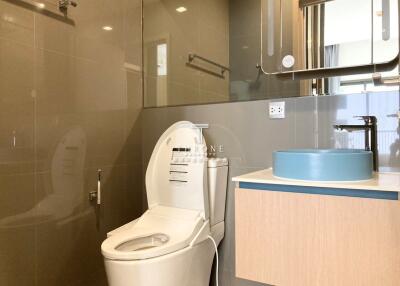 Modern bathroom with toilet, sink, and mirror