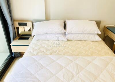 Bedroom with a neatly made bed and large pillows